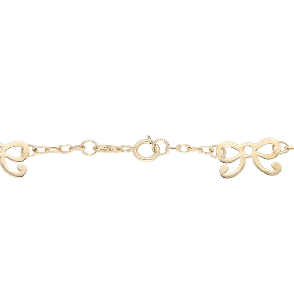 Pulsera eslabón cruzado con aplicación motivo moño en oro amarillo 14 kilates.