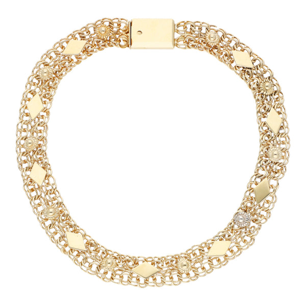 Pulsera eslabón calado con aplicaciones motivo flor en oro dos tonos 14 kilates.