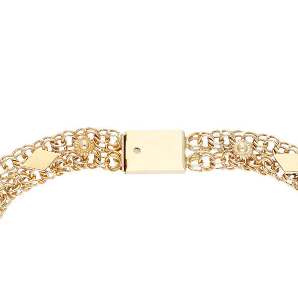 Pulsera eslabón calado con aplicaciones motivo flor en oro dos tonos 14 kilates.