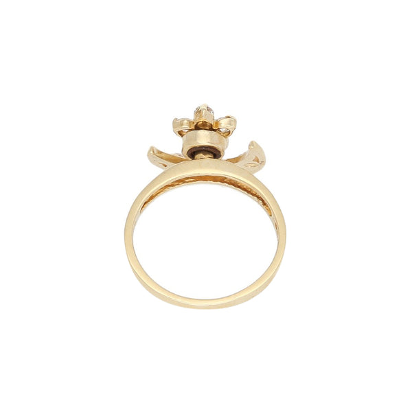 Anillo giratorio con sintéticos motivo media luna y flor en oro amarillo 14 kilates.