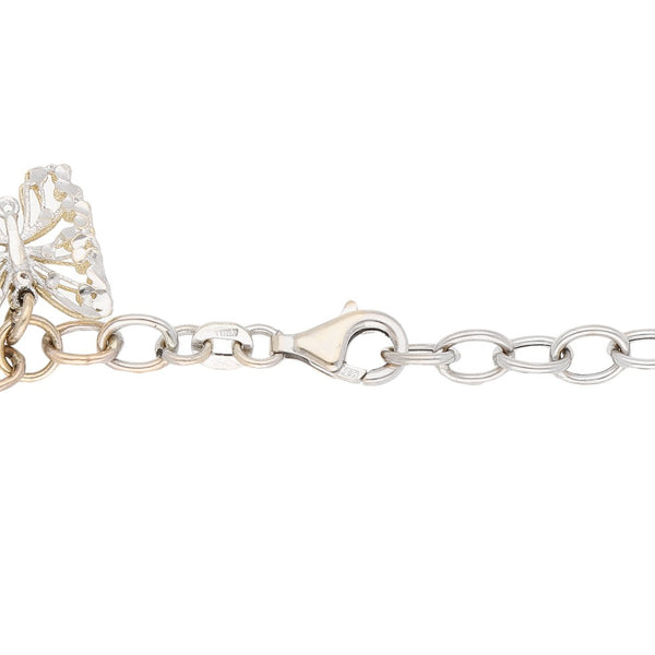 Pulsera eslabón combinado con aplicaciones y colgante motivo esferas y mariposa en oro dos tonos 14 kilates.