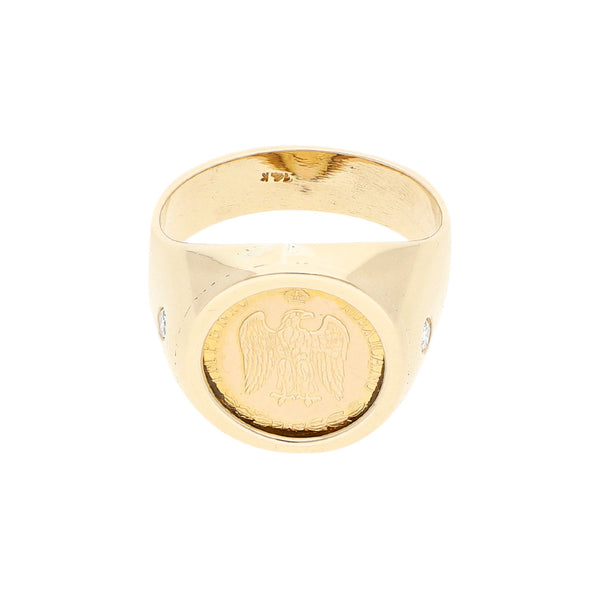 Anillo tipo sello con aplicación de moneda en oro 14 kilates y diamantes en oro amarillo 12 kilates.