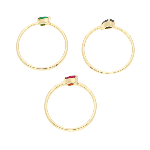 Tres anillos lisos con esmeralda, rubí y zafiro en oro amarillo 14 kilates.