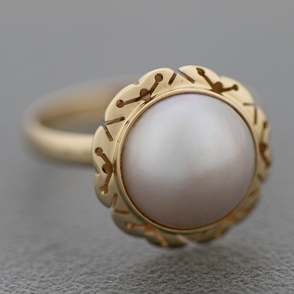 Juego de anillo y aretes calados con media perla en oro amarillo 14 kilates.