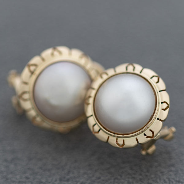 Aretes calados con media perla en oro amarillo 14 kilates.