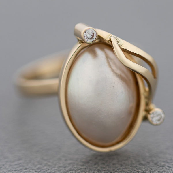 Juego de anillo y aretes diseño especial con medias perla y sintéticos en oro amarillo 14 kilates.