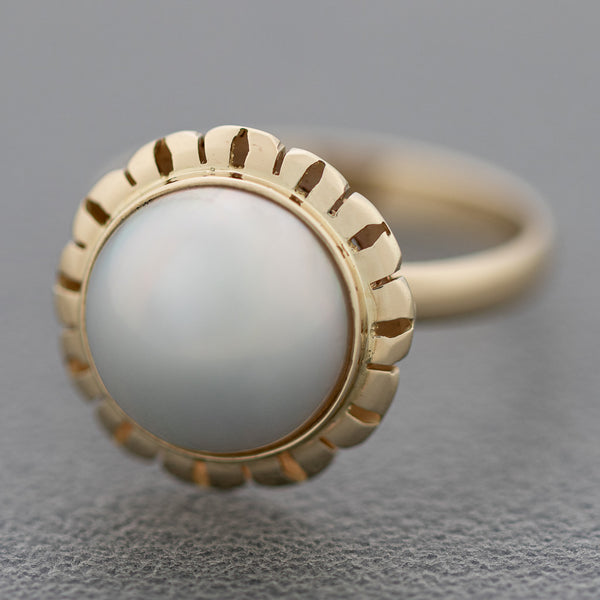 Juego de anillo y aretes calados con perla en oro amarillo 14 kilates.