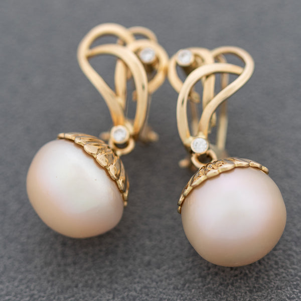 Aretes calados con perla y sintéticos en oro amarillo 14 kilates.
