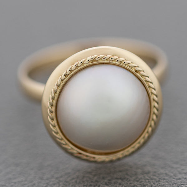 Juego de anillo y aretes torzal con media perla en oro amarillo 14 kilates.
