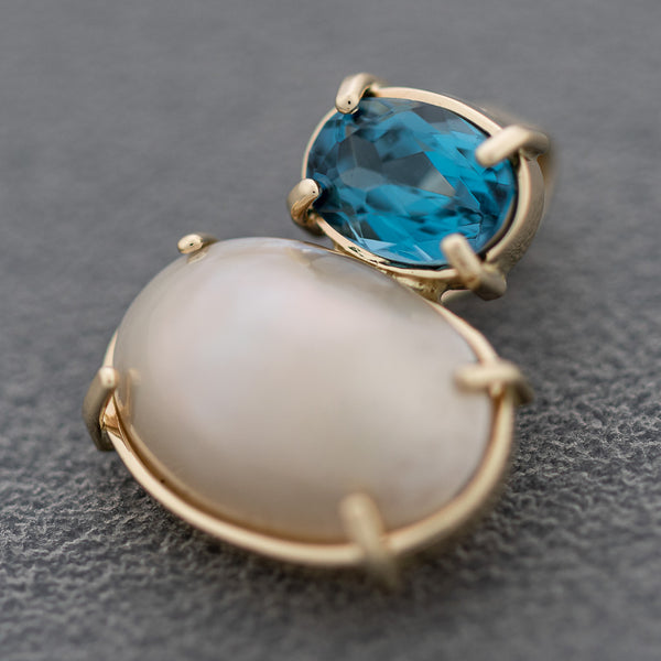 Juego de dije y aretes diseño especial con blue London y media perla en oro amarillo 14 kilates.