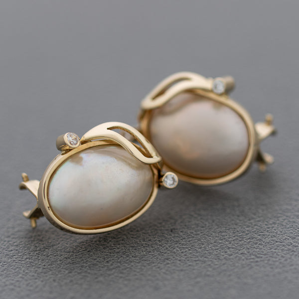 Aretes diseño especial con medias perlas y sintéticos en oro amarillo 14 kilates.