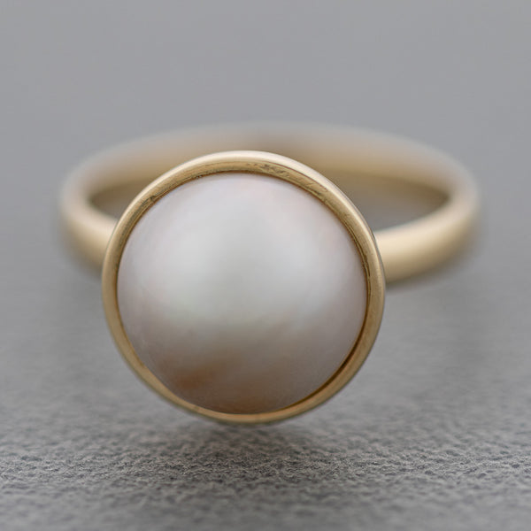 Juego de anillo y aretes diseño especial con medias perlas en oro amarillo 14 kilates.