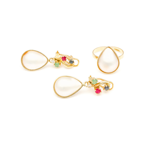 Juego de anillo y aretes con medias perlas y gemas en oro amarillo 14 kilates.