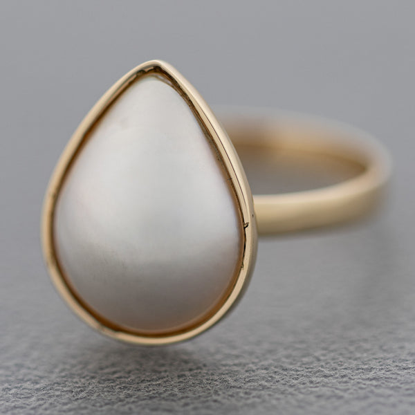 Juego de anillo y aretes con medias perlas y gemas en oro amarillo 14 kilates.