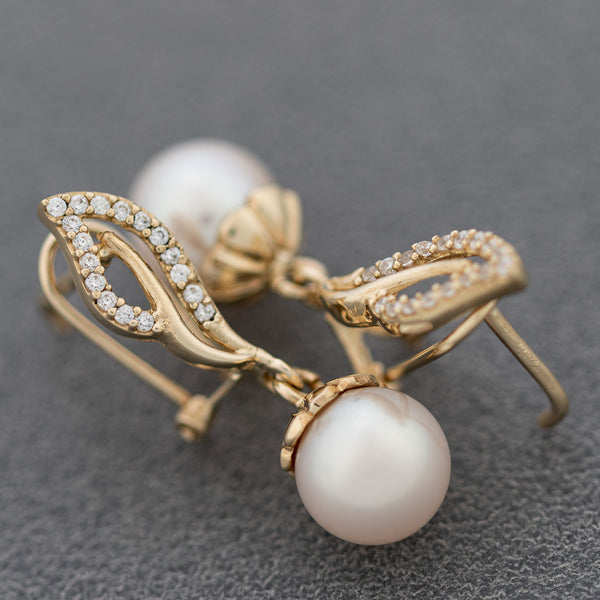 Aretes calados con perla y sintéticos en oro amarillo 14 kilates.