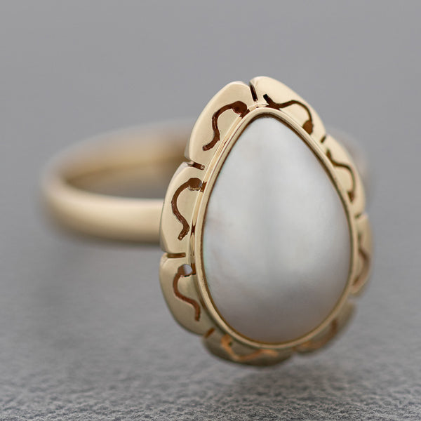 Juego de anillo y aretes calados con medias perlas en oro amarillo 14 kilates.