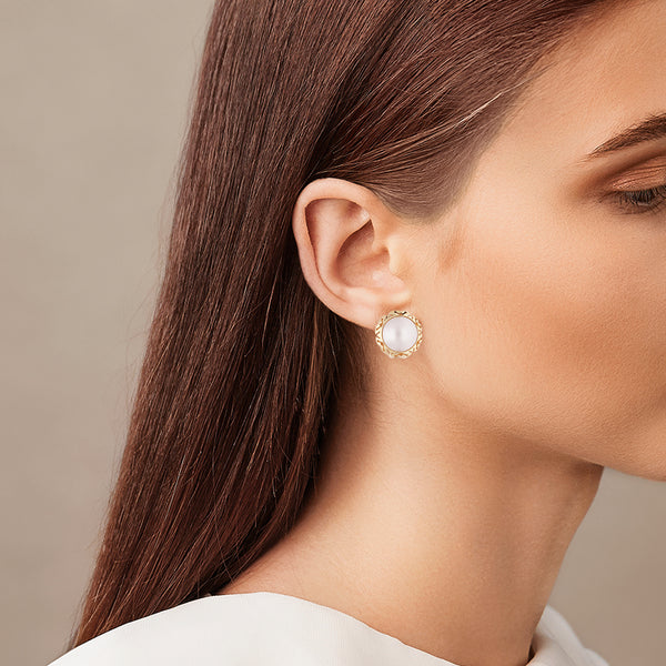 Aretes calados con media perla en oro amarillo 14 kilates.