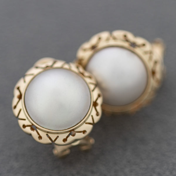 Aretes calados con media perla en oro amarillo 14 kilates.