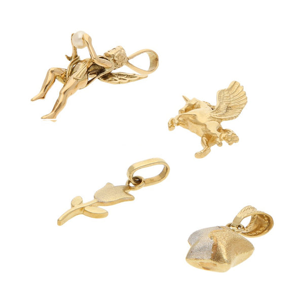 Cuatro dijes diseño especial motivo figuras diversas uno con perla en oro amarillo 14 kilates.