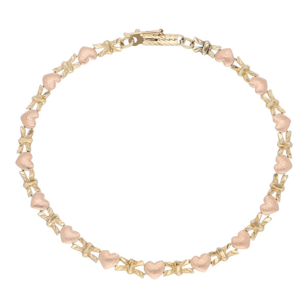 Pulsera eslabón combinado motivo corazón en oro dos tonos 14 kilates.