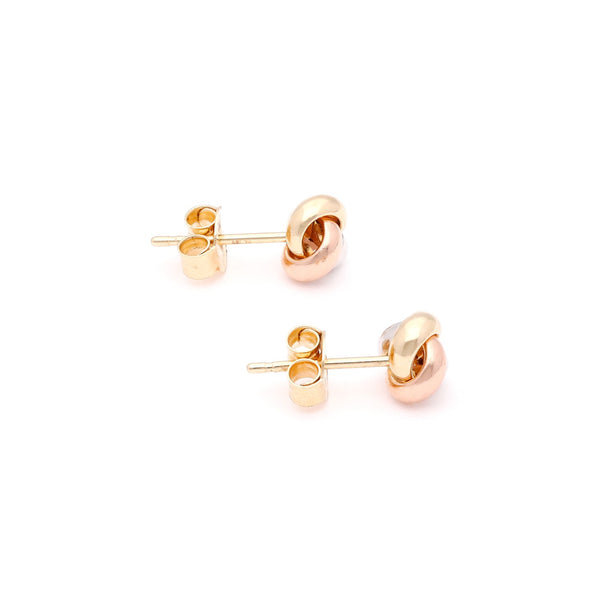 Aretes lisos motivo nudo en oro tres tonos 14 kilates.
