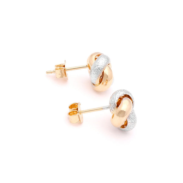 Aretes labrados motivo nudo en oro dos tonos 14 kilates.
