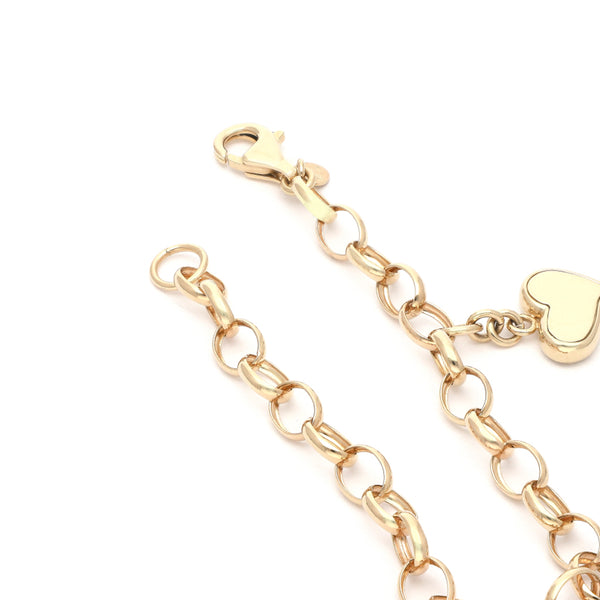 Pulsera eslabón cruzado con colgante motivo corazón en oro amarillo 14 kilates.