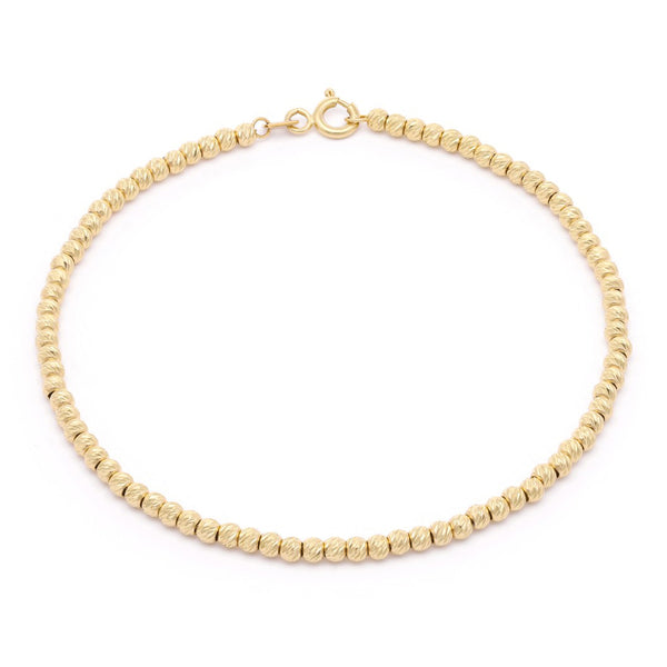 Pulsera eslabón cruzado con aplicaciones motivo esferas en oro amarillo 14 kilates.