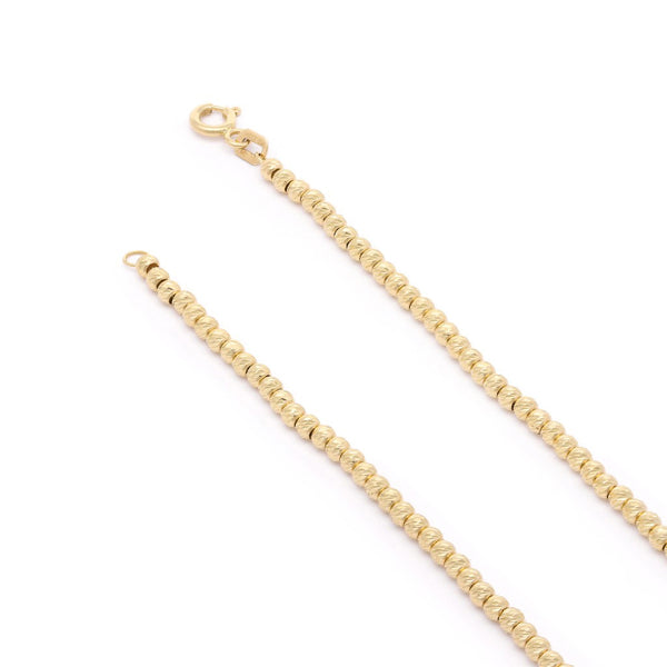 Pulsera eslabón cruzado con aplicaciones motivo esferas en oro amarillo 14 kilates.