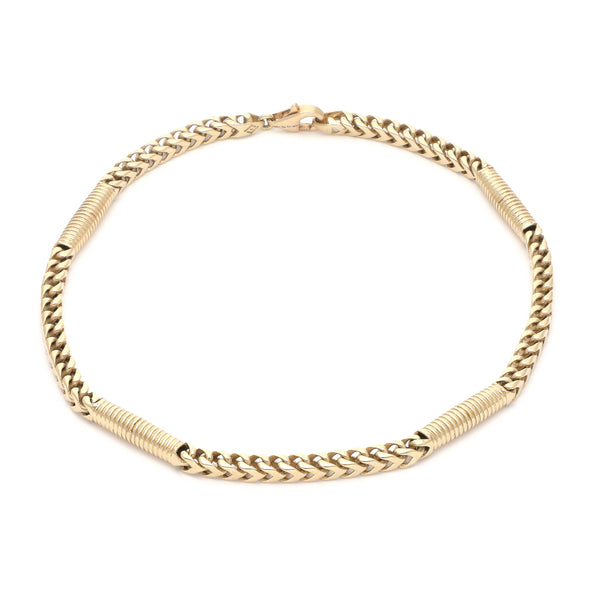 Pulsera eslabón tejido con aplicaciones en oro amarillo 14 kilates.