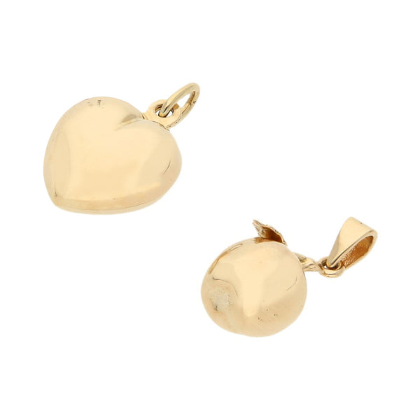 Dos dijes huecos motivo corazón y manzana en oro amarillo 14 kilates.