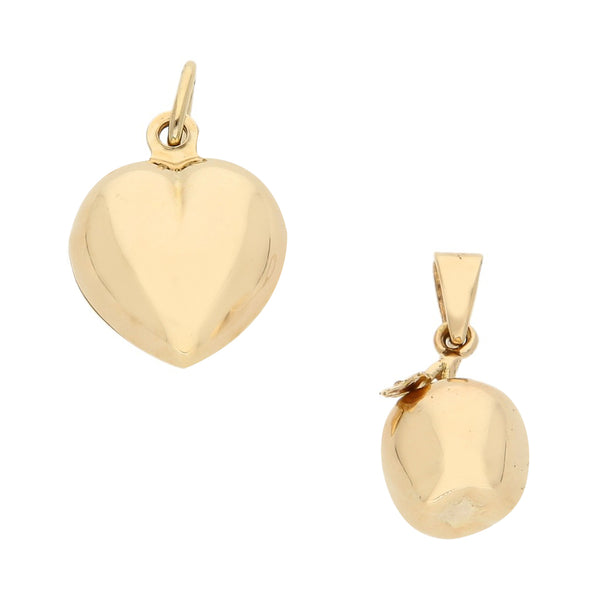 Dos dijes huecos motivo corazón y manzana en oro amarillo 14 kilates.
