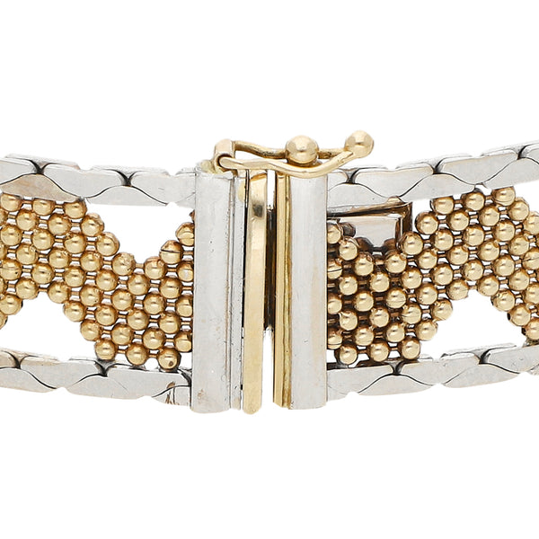 Pulsera eslabón laminado con aplicaciones en oro dos tonos 14 kilates.