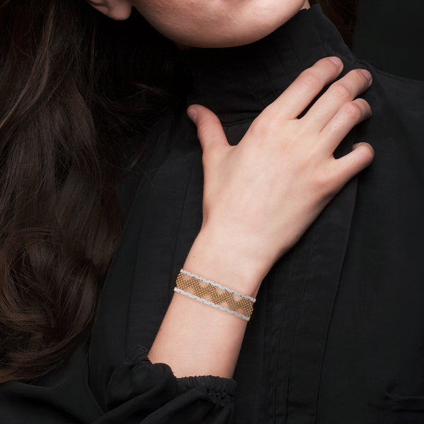 Pulsera eslabón laminado con aplicaciones en oro dos tonos 14 kilates.