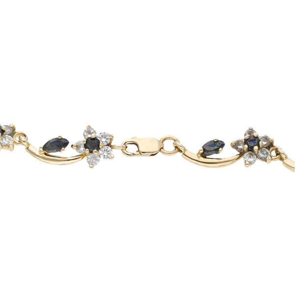 Pulsera eslabón articulado motivo flor con sintéticos en oro amarillo 12 kilates.