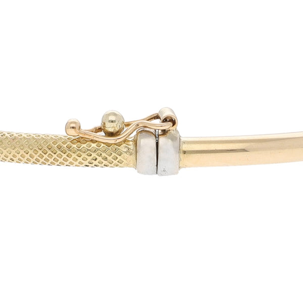 Pulsera de arillo articulada con aplicaciones y circonias en oro dos tonos 14 kilates.