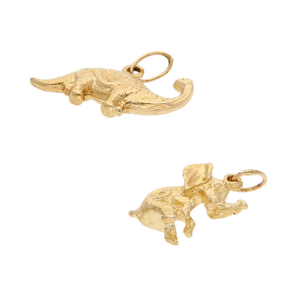 Dos dijes diseño especial motivo elefante y dinosaurio en oro amarillo 14 kilates.