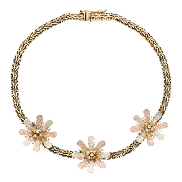 Pulsera eslabón boleado con aplicaciones motivo flores en oro tres tonos 14 kilates.