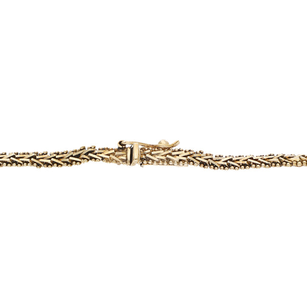 Pulsera eslabón boleado con aplicaciones motivo flores en oro tres tonos 14 kilates.