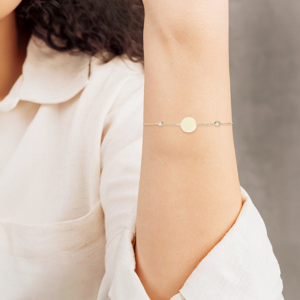 Pulsera eslabón cruzado con aplicaciones motivo círculos con sintéticos en oro amarillo 14 kilates.