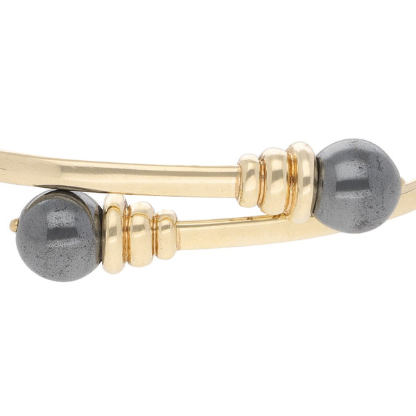 Pulsera de arillo abierta con perlas en oro amarillo 14 kilates.