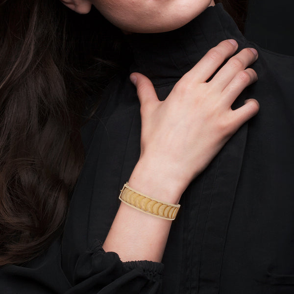 Pulsera de arillo articulada con trece monedas de dos pesos oro mexicano 21.6 kilates en oro amarillo 18 kilates.