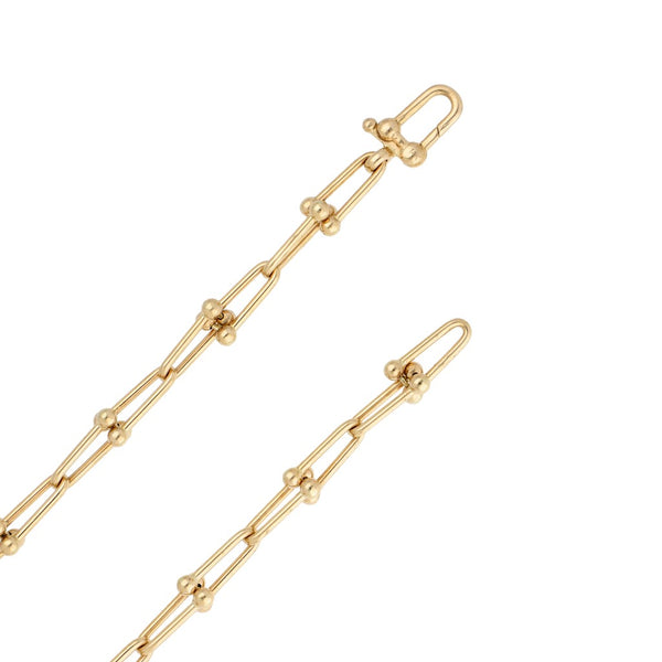 Pulsera de arillo articulada y gargantilla eslabón cruzado en oro dos tonos 14 kilates.