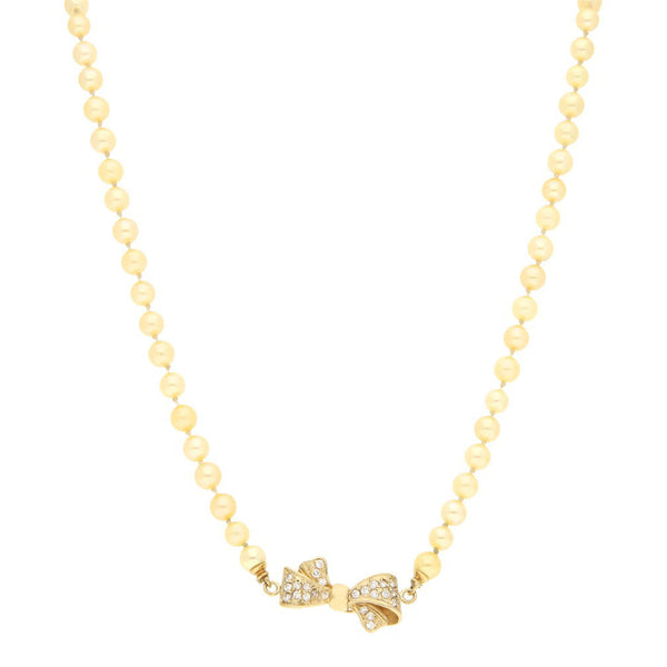 Collar de perlas diseño especial con broche aplicación motivo moño y sintéticos en oro amarillo 14 kilates.