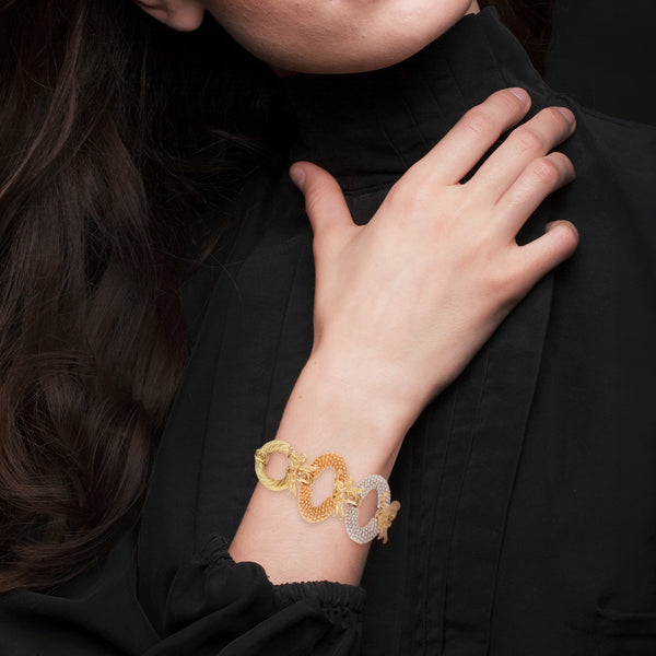 Pulsera eslabón combinado con aplicaciones motivo ángeles en oro tres tonos 14 kilates.