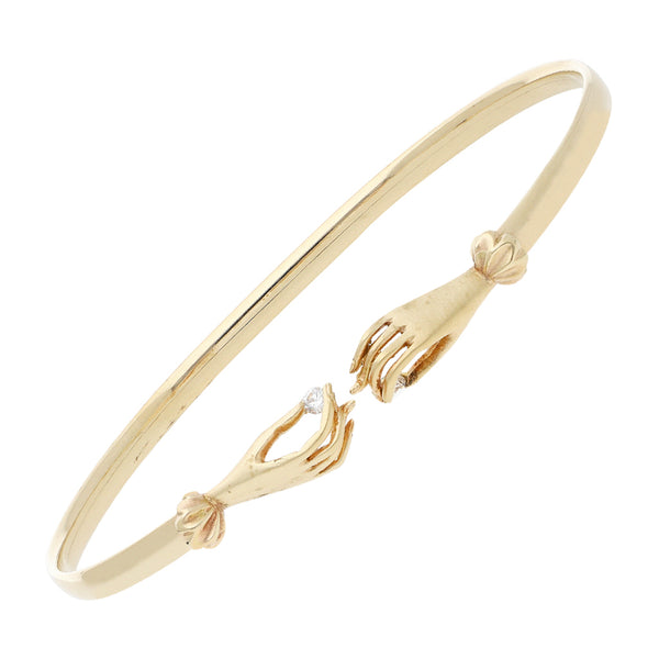 Pulsera de arillo abierta con aplicaciones motivo manos y sintéticos en oro amarillo 14 kilates.