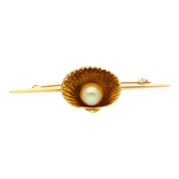 Prendedor hechura especial motivo concha con perla en oro amarillo 14 kilates.