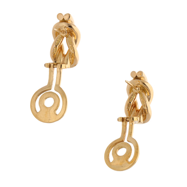 Aretes hechura especial motivo nudo firma Tane en oro amarillo 18 kilates.