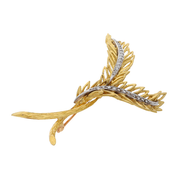 Prendedor estilizado motivo hojas con diamantes en oro dos tonos 18 kilates.