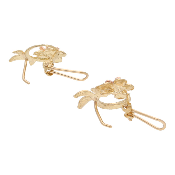 Aretes calados motivo floral en oro dos tonos 10 kilates.